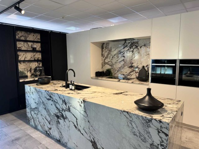 Exclusieve showroomkeuken met luxe keramisch monobloc-eiland, hoogwaardige neff-toestellen en novy dampkap - afbeelding 1 van  23