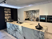 Exclusieve showroomkeuken met luxe keramisch monobloc-eiland, hoogwaardige neff-toestellen en novy dampkap - afbeelding 1 van  23