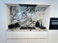 Exclusieve showroomkeuken met luxe keramisch monobloc-eiland, hoogwaardige neff-toestellen en novy dampkap - afbeelding 5 van  23