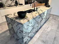 Exclusieve showroomkeuken met luxe keramisch monobloc-eiland, hoogwaardige neff-toestellen en novy dampkap - afbeelding 2 van  23