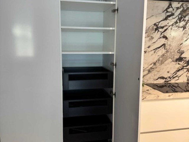 Exclusieve showroomkeuken met luxe keramisch monobloc-eiland, hoogwaardige neff-toestellen en novy dampkap - afbeelding 5 van  23
