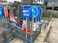 Metalen rek inhoudend diverse verkeersborden en verkeerskegels.