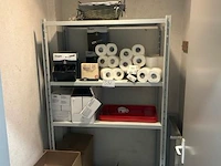 Metalen rek met diverse, toiletpapier en verpakte goederen