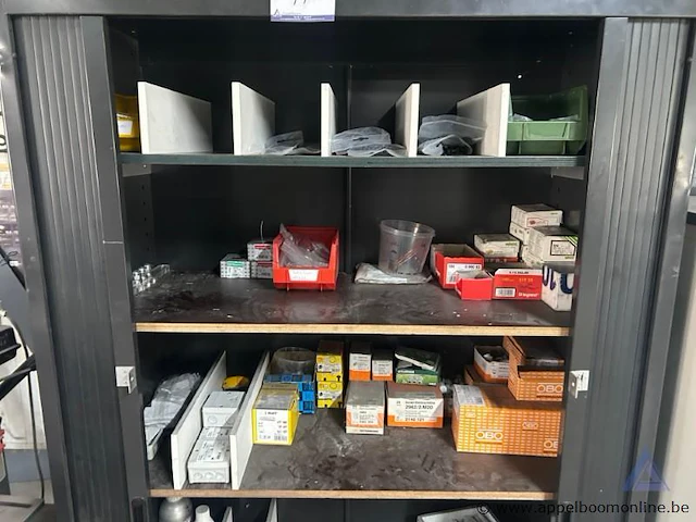 Metalen roldeurkast. de kast is gevuld met diverse materialen, waaronder elektriciteitscomponenten, kabels, tapes en kleine gereedschappen. - afbeelding 2 van  3