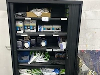 Metalen roldeurkast gevuld met diverse beschermingsmiddelen en filters, waaronder ademhalingsmaskers en filters van 3m en sundström, en beschermende kleding van finixa.