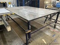 Metalen werktafel met een geperforeerd blad, voorzien van een verrijdbaar onderstel