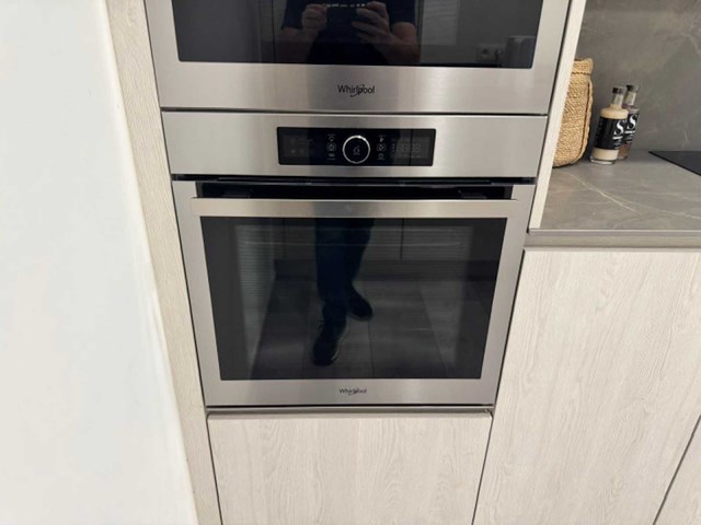 Moderne greeploze keuken in houtmotief met keramisch werkblad en whirlpool-inbouwtoestellen - afbeelding 10 van  15