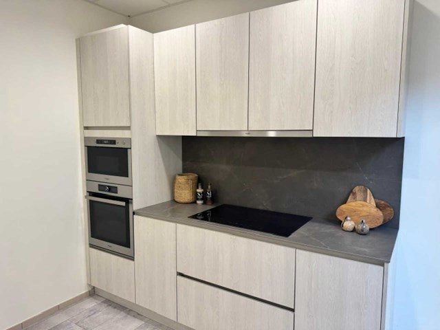 Moderne greeploze keuken in houtmotief met keramisch werkblad en whirlpool-inbouwtoestellen - afbeelding 1 van  15