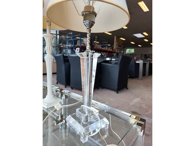 Moderne tafellamp met helder acryl middenstuk en beige stoffen lampenkap riviera maison, moderne tafellamp met kristallen lampenvoet en witte lampenkap met slangenleerstructuur, klassieke tafellamp in oudwit met gedraaide houten voet en beige stoffen kap - afbeelding 3 van  8