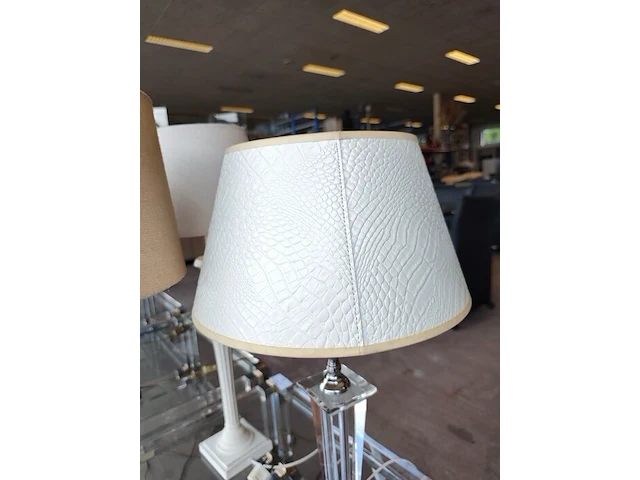 Moderne tafellamp met helder acryl middenstuk en beige stoffen lampenkap riviera maison, moderne tafellamp met kristallen lampenvoet en witte lampenkap met slangenleerstructuur, klassieke tafellamp in oudwit met gedraaide houten voet en beige stoffen kap - afbeelding 4 van  8