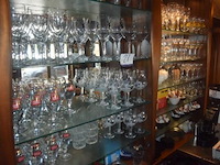 Partij diverse glazen, waaronder bierglazen met logo's, wijnglazen en waterglazen