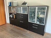 Partij moderne opbergkasten en vitrinekasten met glazen deuren en lades – donker houtdecor - afbeelding 1 van  3