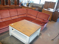 Rose stoffen hoeksalon afm. 300x185, wit houten salontafel bruin houten blad op wielen afm. 100x100, bruin vloerkleed afm. 165x120