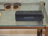 Staande lamp wit, 2 bijzettafeltjes, kruisbeeld, bruin rond houten bijzettafeltje 2 laden, bluetooth speaker anker, 2 zonnebrillen, wandversiering - afbeelding 7 van  10