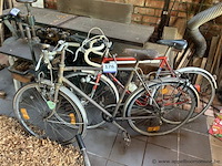 Twee fietsen, bestaande uit een herenfiets met spatborden en bagagedrager, en een racefiets met racestuur.