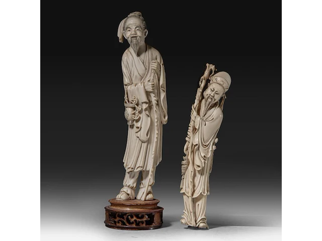 Two chinese ivory sculptures of immortals, late qing dynasty, total h 34 cm - ivory h 30 cm - total weight 888g / h 26 cm - 385g (+) - afbeelding 1 van  7