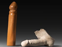 Two contemporary phalluses, plaster and wood, h 25 cm (the wooden)
