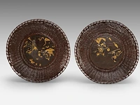 Two decorative japanese plates with bronze bassins set in wicker rims, decorated in gold relief with scenes of families playing with puppets and making music, meiji period (1868-1912), ø 27,5 cm