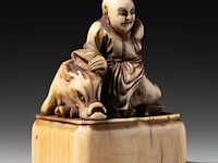 Two japanese ivory netsuke, one of a sitting dog, the other of roshi and an ox, both edo period, h 3,3 cm - w 3 cm - d 1,8 cm - 10g / h 4,3 cm - 27,6g (+) - afbeelding 9 van  13