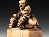 Two japanese ivory netsuke, one of a sitting dog, the other of roshi and an ox, both edo period, h 3,3 cm - w 3 cm - d 1,8 cm - 10g / h 4,3 cm - 27,6g (+) - afbeelding 10 van  13