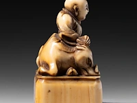 Two japanese ivory netsuke, one of a sitting dog, the other of roshi and an ox, both edo period, h 3,3 cm - w 3 cm - d 1,8 cm - 10g / h 4,3 cm - 27,6g (+) - afbeelding 13 van  13