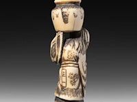 Two japanese ivory netsuke, one of a woman carrying a large jug, signed masakazu, the other of a resting man, edo/meiji period (19thc), h 6 cm - 15,9g / h 2 cm - 14g (+) - afbeelding 6 van  7