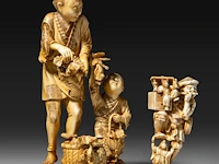 Two japanese ivory okimono, one of a farmer with his son, the other of a street entertainer, meiji period (1868-1912), h 16,5 cm - 328g / h 6,5 cm - 75g (+)