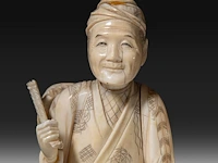 Two japanese ivory okimono, one of a man calling on one of the gods of good fortune, the other a man carrying a basket, meiji period (1868-1912), h 25,5 cm - 358g / ivory h 20,5 cm - 340g (+) - afbeelding 6 van  8