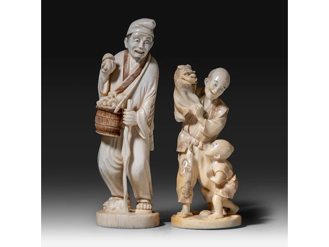 Two japanese ivory okimono, one of a man picking mushrooms, the other of a puppeteer and a child, meiji period (1868-1912), h 20 cm - 493g / h 16 cm - 319g (+) - afbeelding 1 van  10