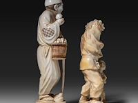Two japanese ivory okimono, one of a man picking mushrooms, the other of a puppeteer and a child, meiji period (1868-1912), h 20 cm - 493g / h 16 cm - 319g (+) - afbeelding 6 van  10