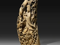 Two japanese whale tooth okimono, one of a man with a drum, signed; the other of gyoran kannon riding a large carp into a bamboo forest, both meiji period (1868-1912), h 15 cm / 13,5 cm (*)