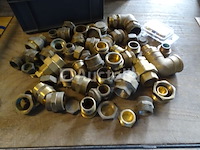 Verschillende messing fittingen in een pvc-bak