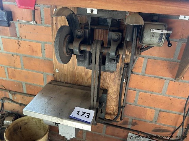 Wandgemonteerde slijpmachine met riemaandrijving, voorzien van een slijpschijf en een werkblad. inclusief bedieningskast - afbeelding 1 van  1