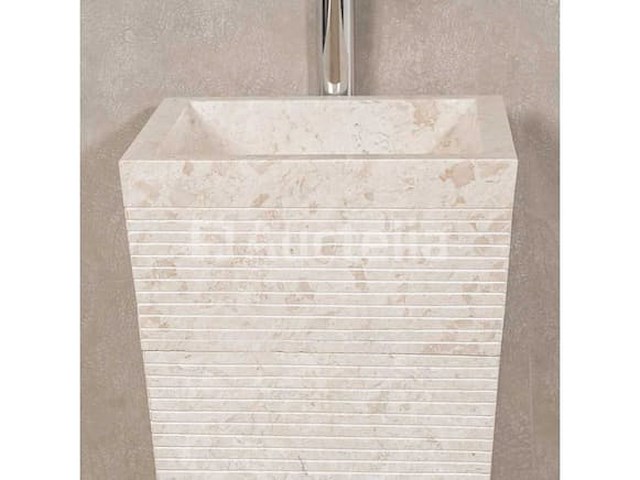 Waswasbak in de badkamer op een voetstuk van crèmekleurige piramidesteen - afbeelding 1 van  2