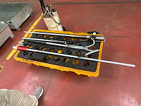 Werkplaatsgereedschap op gele opvangbak – smeerpistool, sproeitoestel en metalen staven - afbeelding 2 van  3