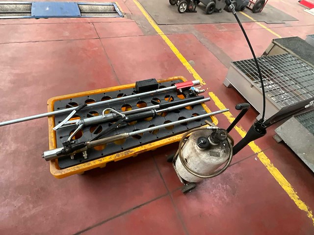 Werkplaatsgereedschap op gele opvangbak – smeerpistool, sproeitoestel en metalen staven - afbeelding 3 van  3