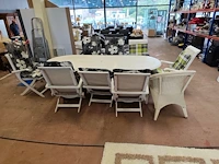 Witte tuinset uit kunststof bestaande uit een ovale tafel 240x110 cm, 8 plooistoelen met kussens, wit rotan zeteltje